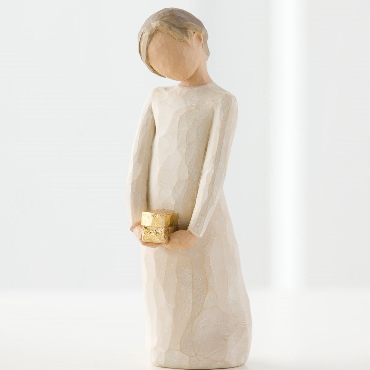 Willow Tree 'Spirit of Giving' Figurine. A young girl holding a cube of gold, with head tilted.