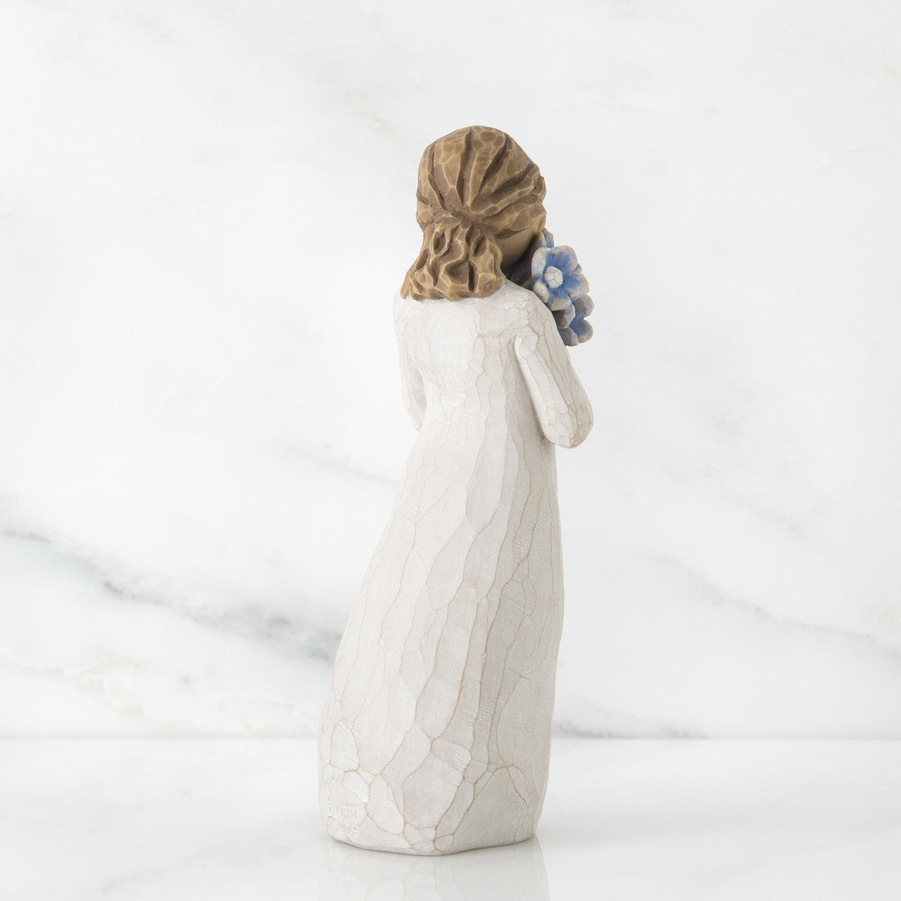 Willow Tree 'Forget-me-not' figurine. A girl holding a bouquet of blue flowers.