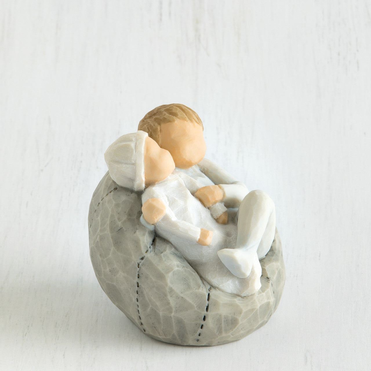 Willow Tree 'My new Baby' Figurine. Depicting a young child wearing blue holding a new baby also wearing blue.