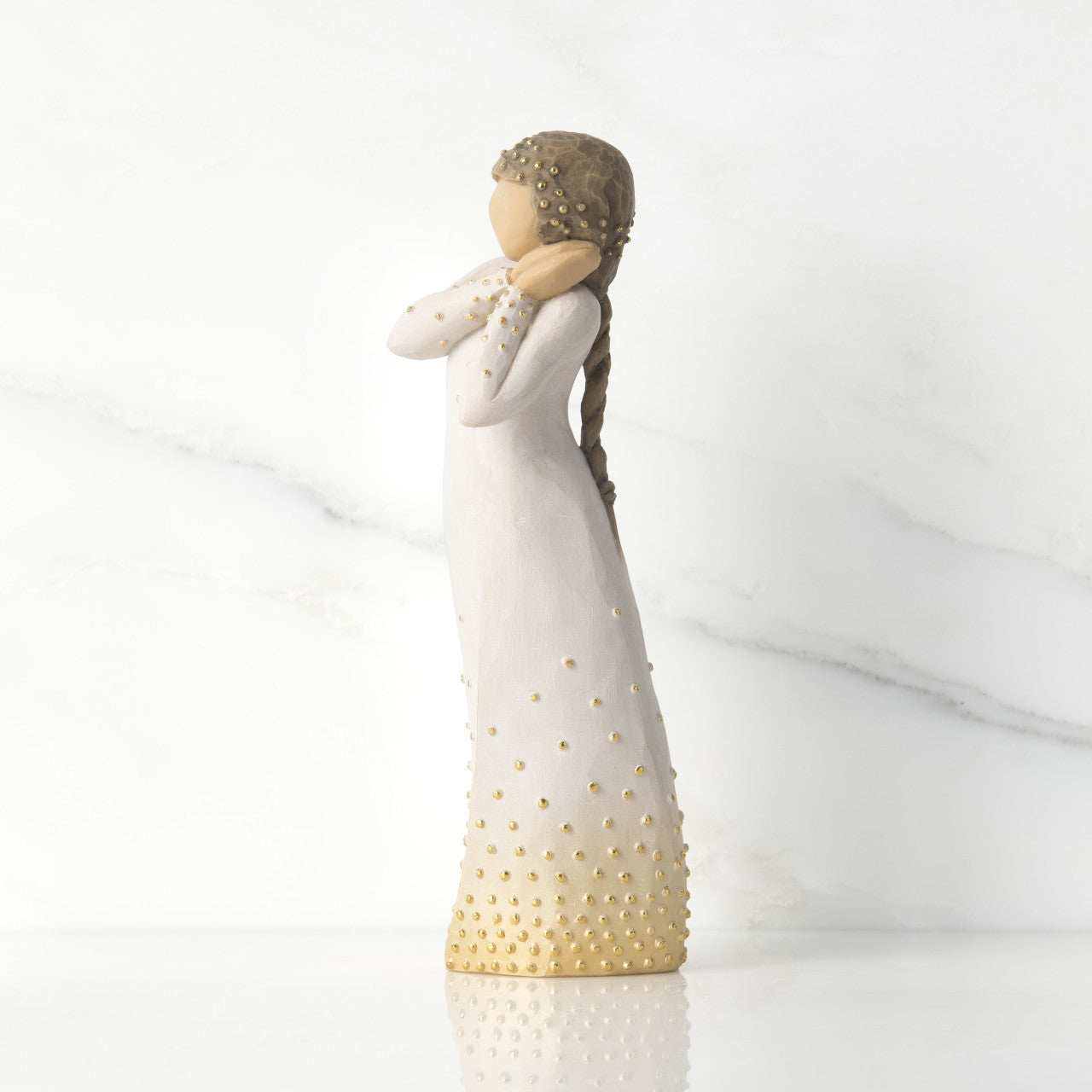 Willow Tree 'Wishing' Figurine. A female figure with tilted head resting on clasped hands, a hand-painted resin with applied gold leaf detail.
