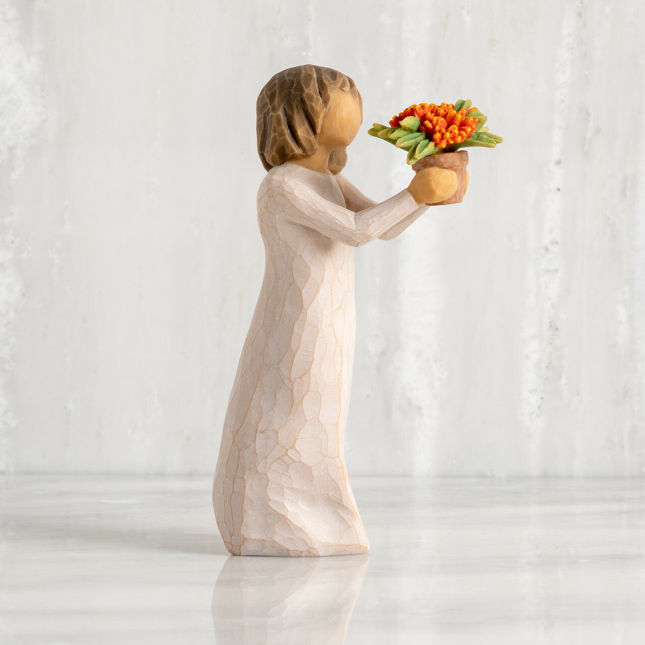 Willow Tree 'Little Things' Figurine. A young girl holding out a flower pot full of orange flowers.