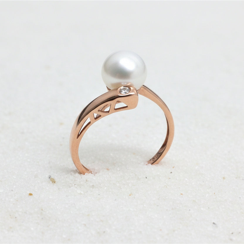 9ct rose gold asymmetrical ring featuring a white freshwater pearl and a small diamond.