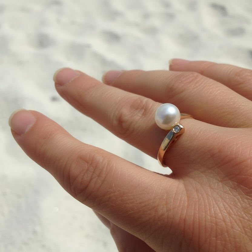 9ct rose gold asymmetrical ring featuring a white freshwater pearl and a small diamond.