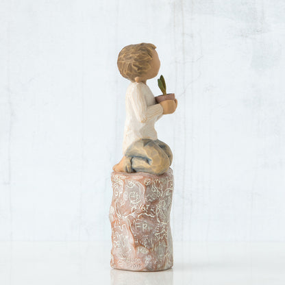 Willow Tree 'Something Special' Figurine. A young boy seated on a detailed stump holding a small potted plant.