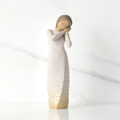 Willow Tree 'Wishing' Figurine. A female figure with tilted head resting on clasped hands, a hand-painted resin with applied gold leaf detail.